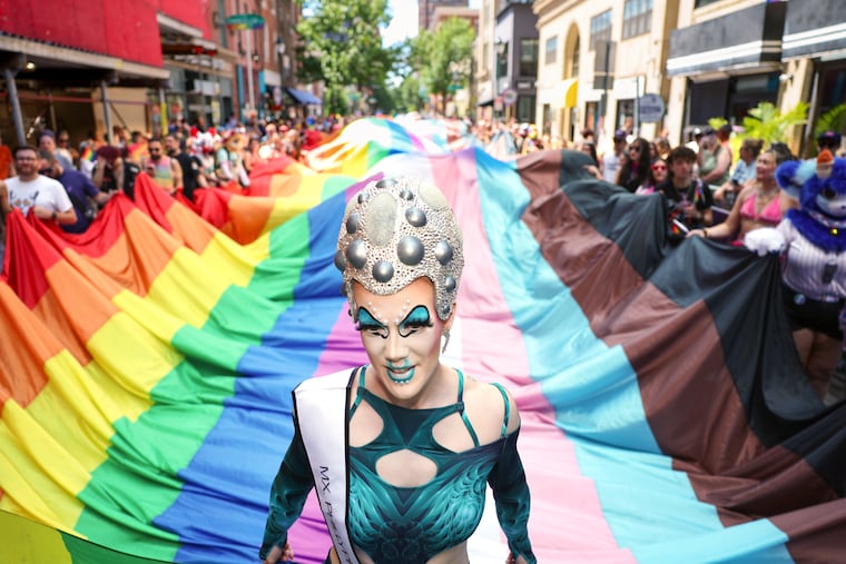 Edith Wiggles and Giggles leads the large Pride flag as it moves along 13th Street during the annual Pride Parade.