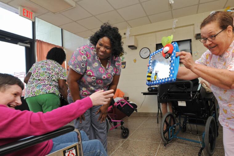 At the Vineland site, Marianita Velez (right) and Bonnie Russell (center) work with Corrine Cowen. (April Saul / Staff Photographer)