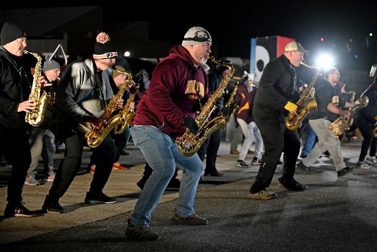 The Avalon String Band rehearse outside their warehouse workshop in a trucking company parking lot under the Betsy Ross Bridge in preparation for Sunday’s Mummers Parade. The band’s theme for the 2023 parade is “All Hands On Deck.”