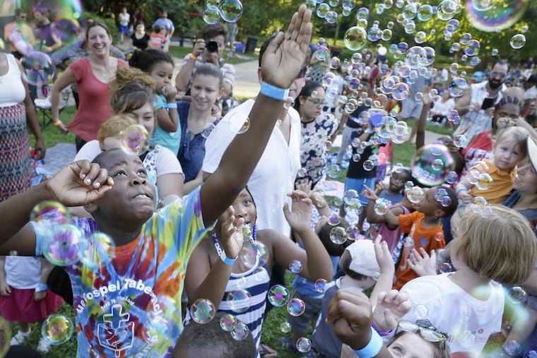 Children play in the bubbles during a program last year at Philadelphia's Smith Memorial Playground.