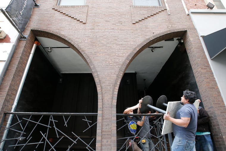 Workers on Saturday carry tables out of the closed Franklin Mortgage & Investment Co., which had helped usher in the era of 'speakeasy' cocktail bars in Philadelphia.