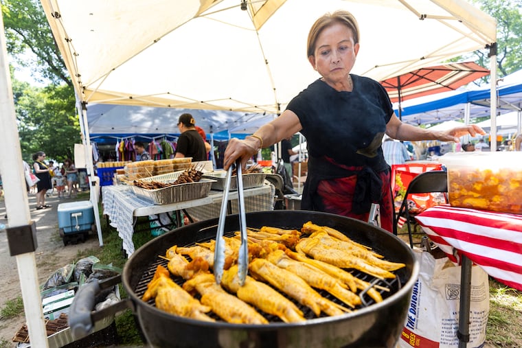 Hong Rattana, of Northeast Philadelphia, cooking some chicken wings on the grill at the Southeast Asian Market in FDR Park, in Philadelphia, Pa., on Saturday, May, 25, 2024.