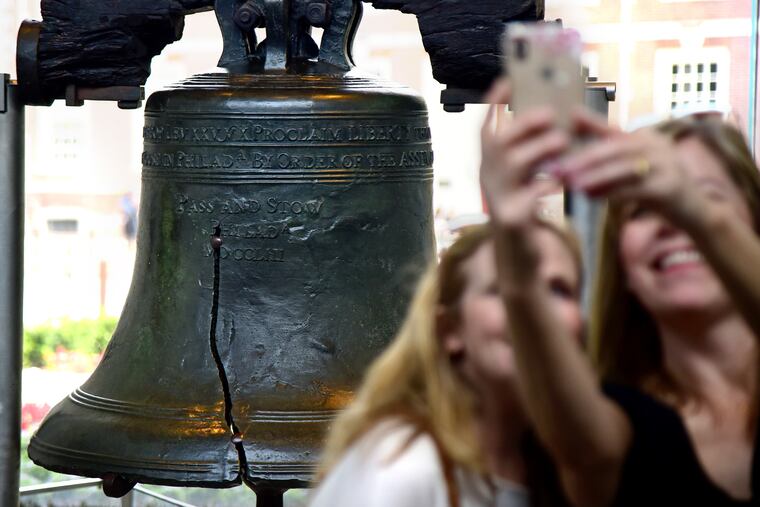 Tourists visit and take selfies in front of the Liberty Bell.