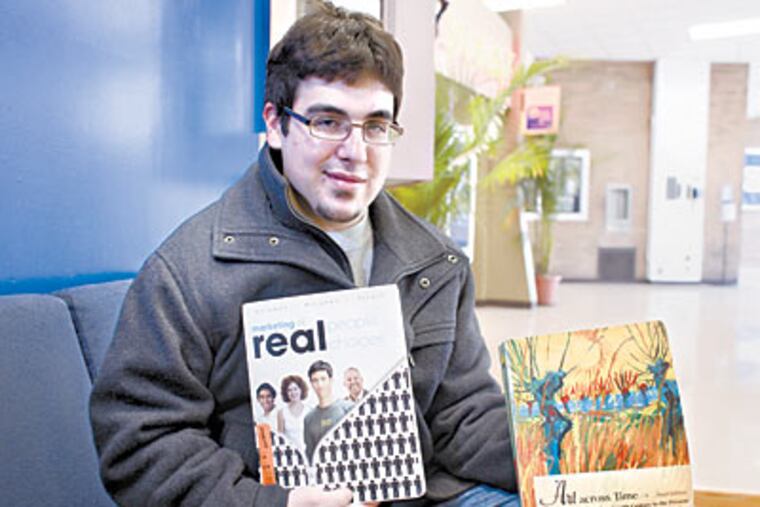 Vinny Vella, a LaSalle University sophomore, holds two text books he's rented this semester. ( Ed Hille / Staff Photographer )