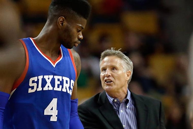 Philadelphia 76ers head coach Brett Brown, right, goes over a play with forward Nerlens Noel (4) during the second half of a preseason basketball game against the Boston Celtics in Boston, Monday, Oct. 6, 2014. The Celtics defeated the 76ers 98-78. (Charles Krupa/AP)