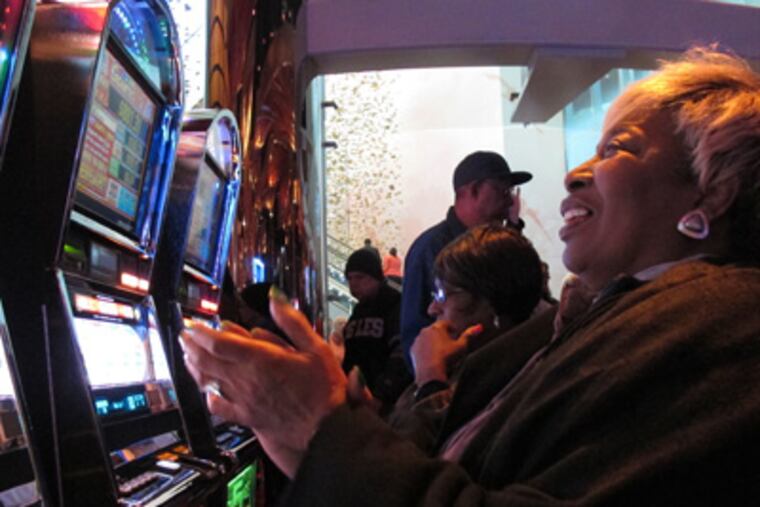 Lorraine Capers, of Brooklyn, N.Y., claps after winning seven free spins on a slot machine at the new $2.4 billion Revel casino resort moments after it opened in Atlantic City, N.J., on Monday, April 2, 2012. (AP Photo/Wayne Parry)