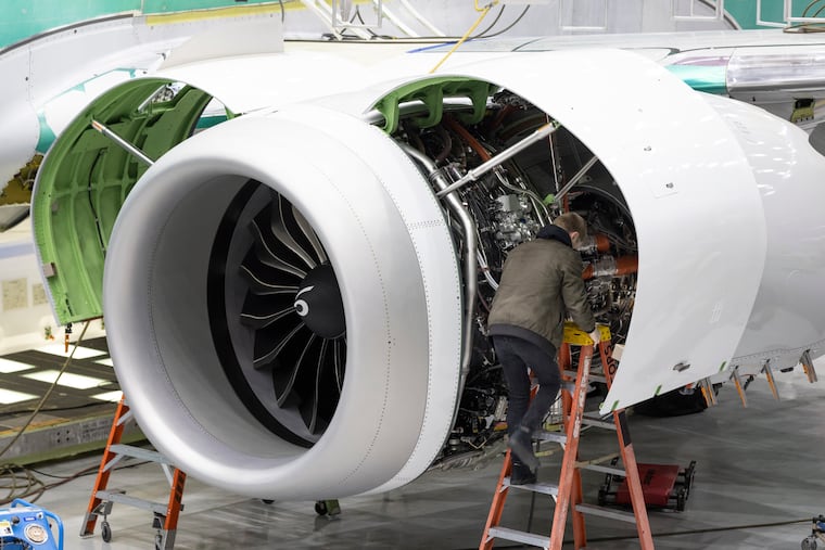 A Boeing employee works on the engine of a 737 Max on the final assembly line at Boeing's Renton plant in Renton, Wash. Delta is ordering 100 of Boeing's 737 Max 10 airplanes, with an option to purchase 30 more, as the airline looks to keep up with surging travel demand.