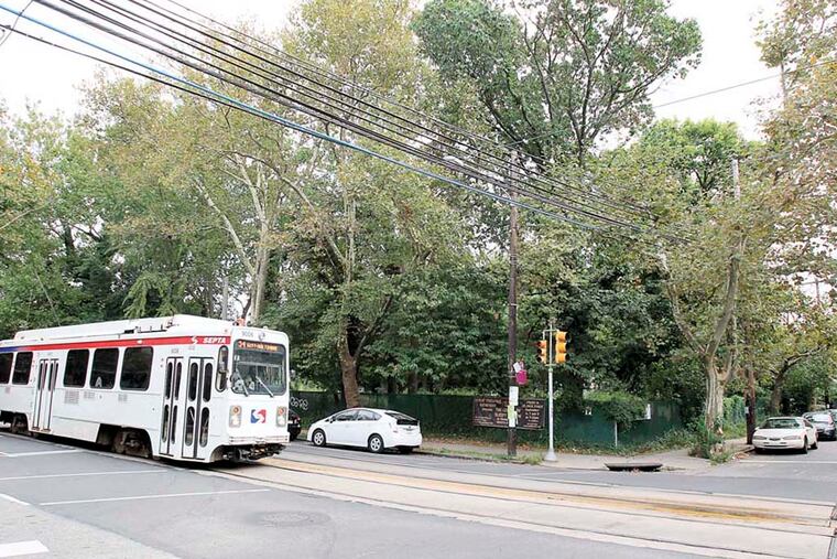 Developers seeking to build a larger-than-allowed apartment building on Baltimore Ave. and 43rd St. in West Philly's Spruce Hill neighborhood asked the community to help with the design. A SEPTA trolley goes by the site on Baltimore Ave. on Sept. 9, 2013. ( CHARLES FOX / Staff Photographer )