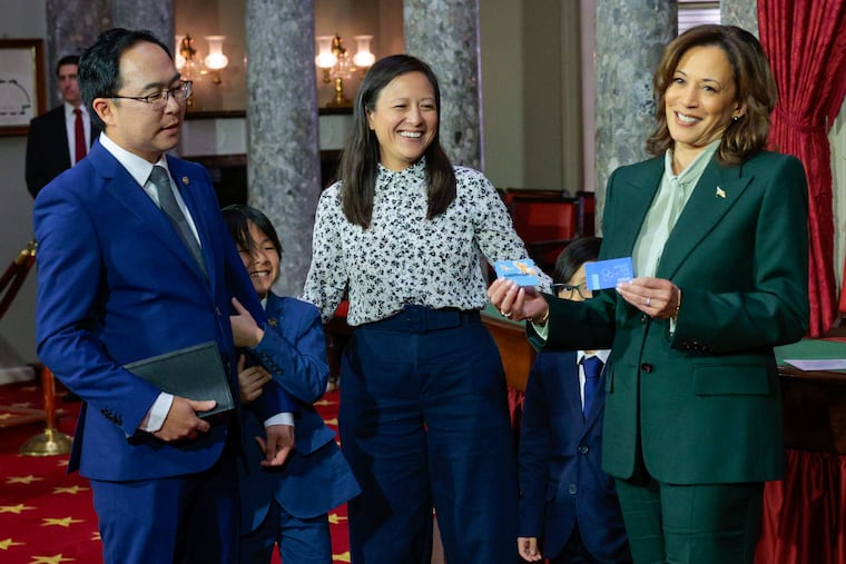 Vice President Kamala Harris holding business cards from New Jersey Sen. Andy Kim’s children at his ceremonial swearing-in ceremony Jan. 3 in Washington.