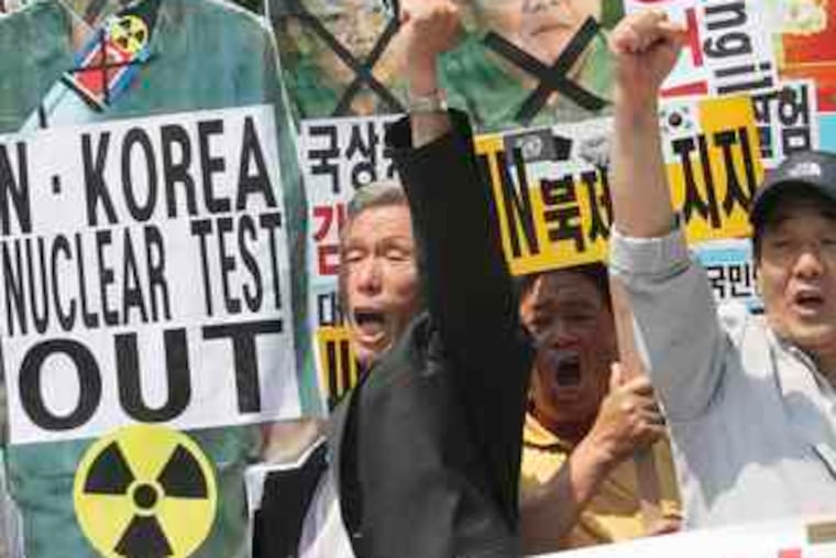 South Koreans carrying defaced pictures of North Korean leaderKim Jong Il join in a rally yesterday near the U.S. Embassy in Seoul.