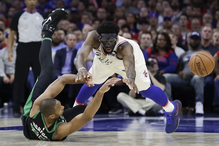 Joel Embiid and Al Horford chase after the ball in the fourth quarter on Monday.