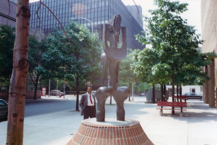 John Rhoden beside his public art sculpture "Nesaika" installed at the front entrance of the Afro-American Historical and Cultural Museum.