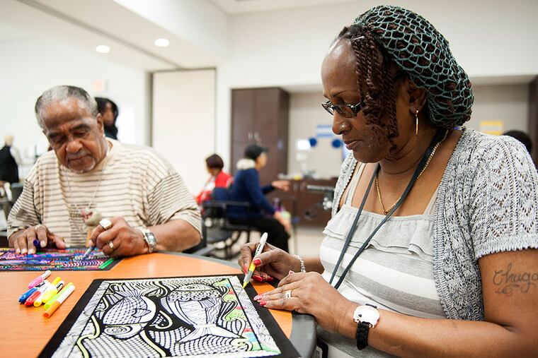Yvonne Brown colors with George Waters at the NewCourtland LIFE Senior Center on Allegheny Avenue in Philadelphia. Brown, who attends the center Tuesday through Thursday, says it is a big help as she recovers from surgeries. MICHAEL PRONZATO / Staff Photographer