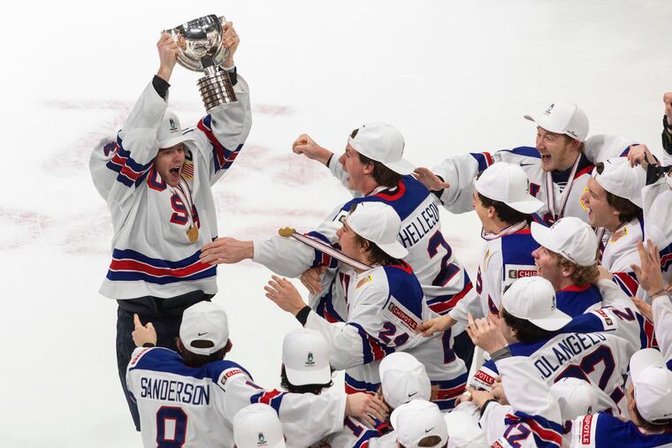 Cam York (4) hoists the World Juniors trophy after the the U.S.'s win in the title game of the 2021 IIHF World Junior Hockey Championship.