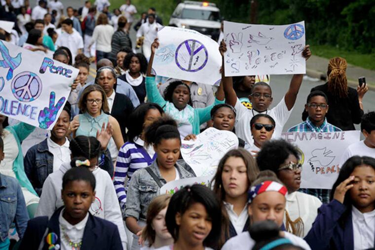 Students from the Creative Arts Morgan Village Academy in Camden hold a peace walk in honor of Matthew Riley, 18,a classmate who was injured in an April 28 shooting. The walk was followed by an assembly.