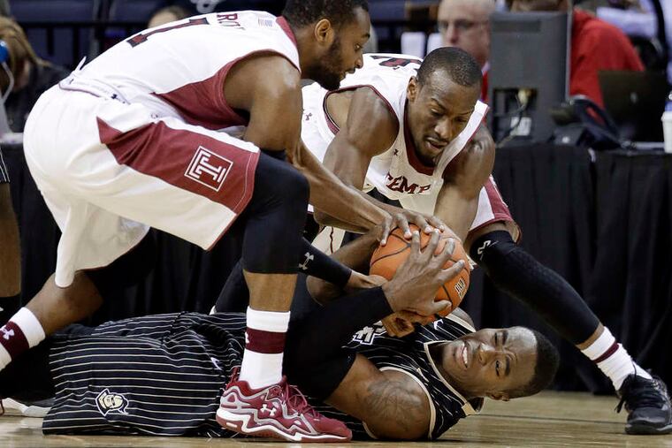 Central Florida guard Isaiah Sykes wrestles for the ball with Temple's Josh Brown (left) and Will Cummings in the first half in Memphis.