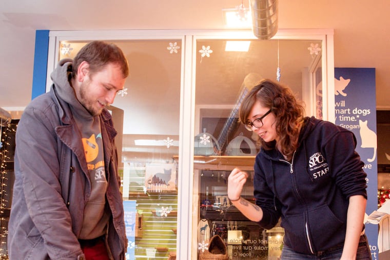 Volunteer Justin Bell and SPCA site supervisor Rachael Small play with Zuul, a dog Bell adopted in July. The location offers a variety of pet-related services and education.