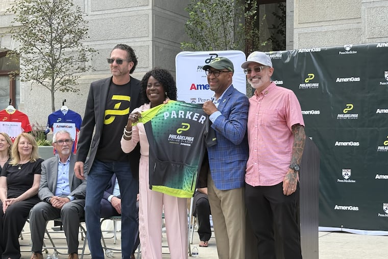 Philadelphia Mayor Cherelle L. Parker (center left) and former Mayor Michael Nutter (center right) pose for a photo with a commemorative Philadelphia Cycling Classic jersey on Friday, Aug. 28, outside Philadelphia City Hall.