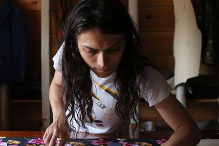 Tailor Sam Hubler measures fabric for an Ikiré Jones jacket.