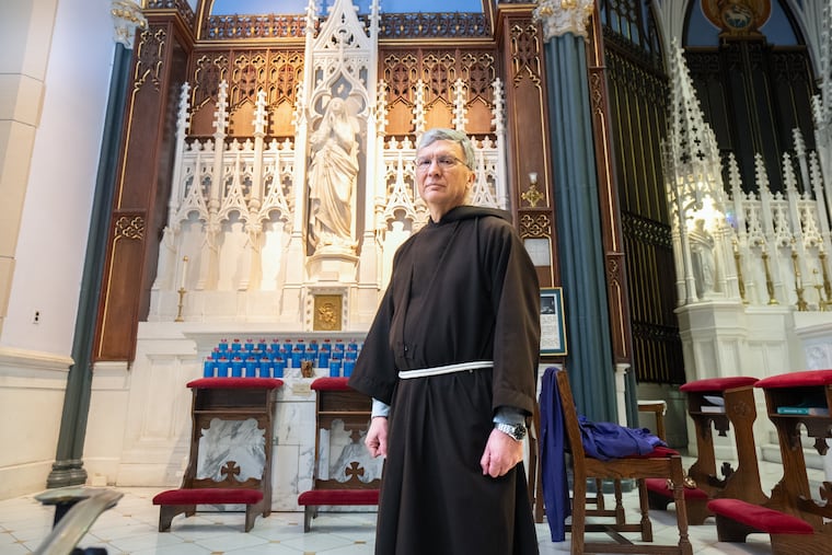 Father Tom Betz stands in front of statue whose gold jeweled crown was stolen by a thief who broke into the historic St. John the Evangelist Church in East Market.