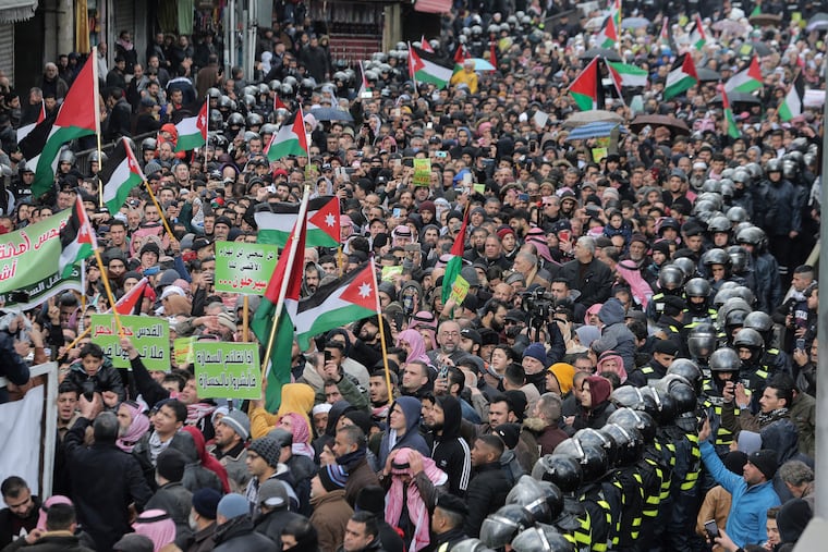 Protesters carry Jordanian and Palestinian flags and slogans during a protest against the Middle East peace plan proposed by U.S. President Donald Trump, in the center of Amman, Jordan, Friday, Jan. 31, 2020.