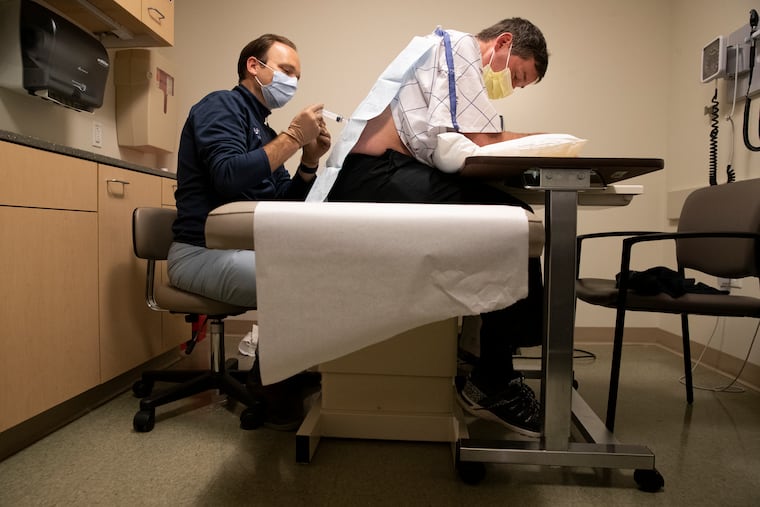 Colin Quinn injects Todd Legg with a newly approved drug for ALS at Penn's Perelman Center for Advanced Medicine. Quinn says the drug has helped stabilize Legg's condition.