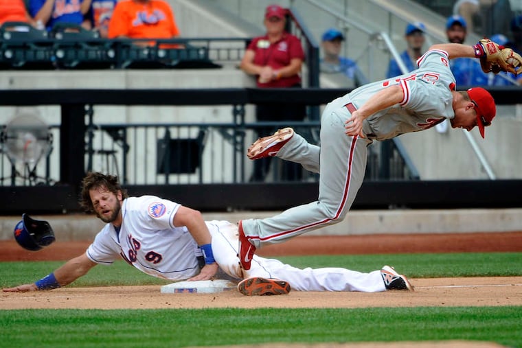 The Mets’ Kirk Nieuwenhuis steals third base as the Phils’ Cody Asche goes flying in the eighth inning. Nieuwenhuis later scored what proved to be the decisive run.