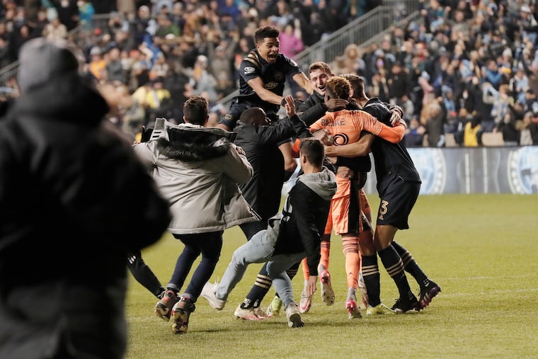 Andre Blake was swarmed by his teammates after the shootout win.