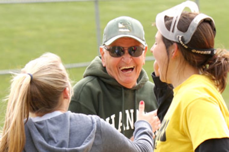 Ron Savastio, Bishop Shanahan’s 79-year-old softball coach, laughs while high-fiving his players after a practice drill Thursday (4/12/12). (LOU RABITO / Staff)