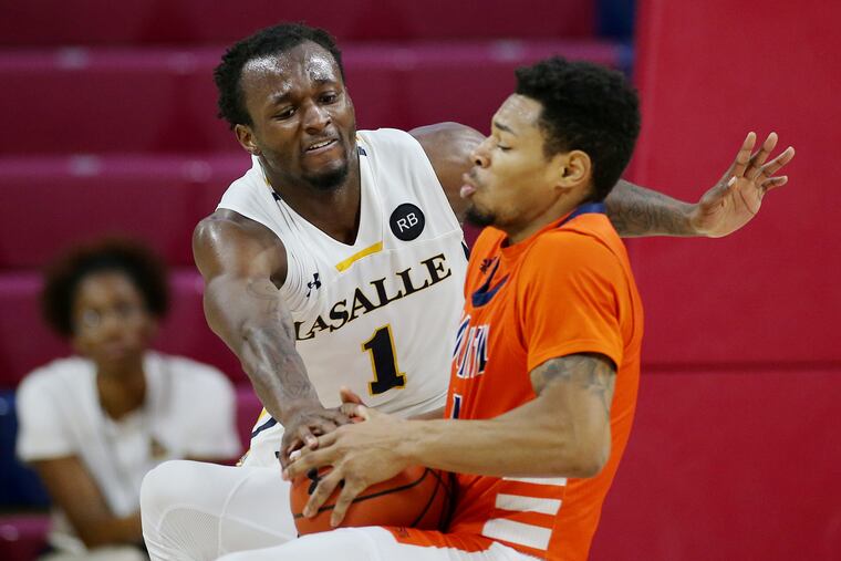 La Salle guard David Beatty (1) and Bucknell guard Avi Toomer (11) fight for the ball at the Palestra on Saturday, Dec. 28, 2019. La Salle won 71-59.
