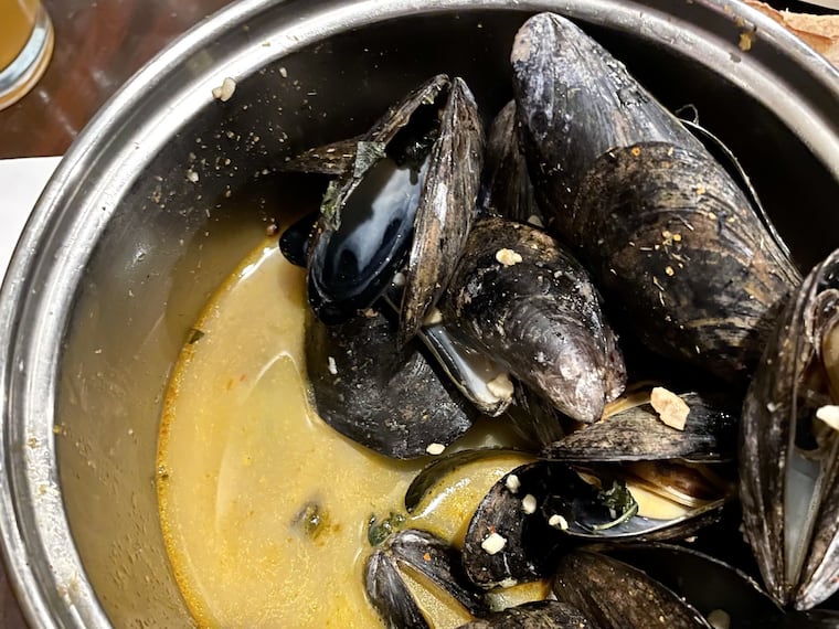 A pot of mussels in Thai curry broth at Monk's Cafe.