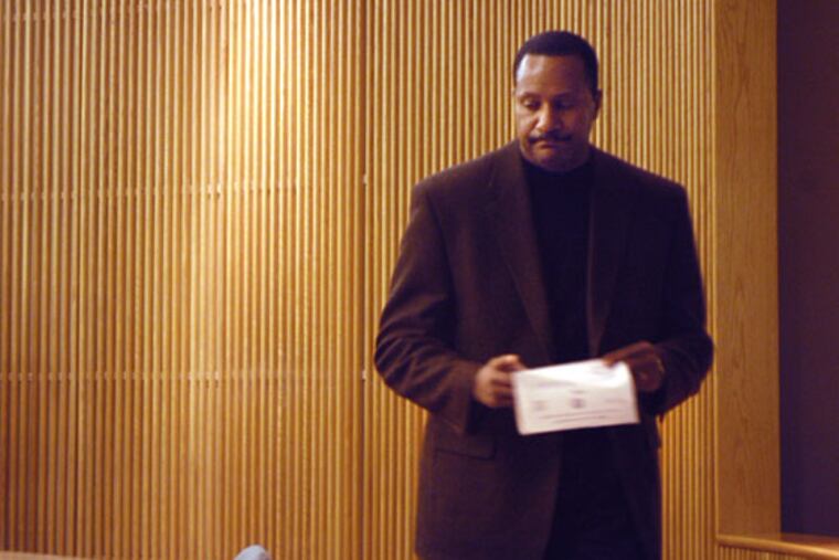 Terence Jones signs paperwork as his hearing is postponed in Superior Court in Woodbury on Monday morning.