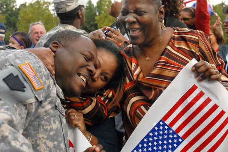 Sgt. Nate Hollis of Mount Airy is greeted by his fiancee, Crystal Gilliam (center), and his mother, Thelma Hollis, after arriving in Philadelphia with other Alpha Company soldiers who served in Iraq.