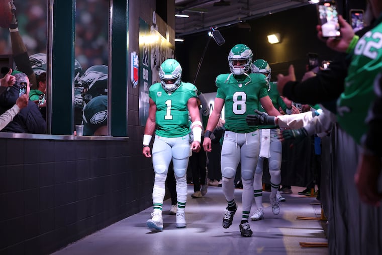 Eagles quarterback Jalen Hurts (1) and former backup Marcus Mariota before a game against the Miami Dolphins on Oct. 22.