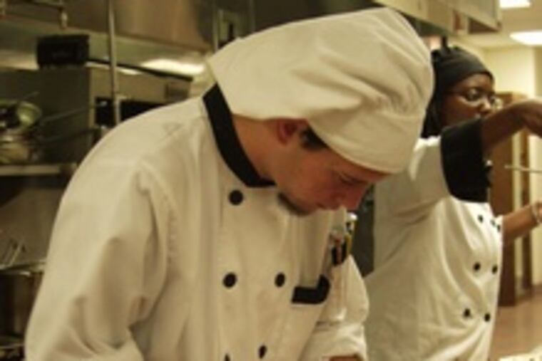 new tastes and new techniques," said senior Francis Hagan of the kitchen experience. He and junior Tyshima Hicks plate Asian-inspired dishes.