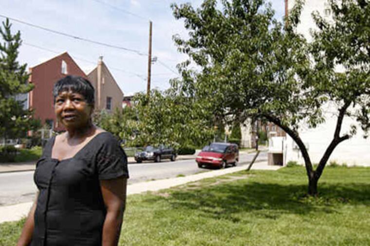 Vivian VanStory, founder and chief executive officer of the Community Land trust Corp., stands on the lot at 15th and Cabot streets where a beloved peach tree grows. (David Maialetti / Staff Photographer)