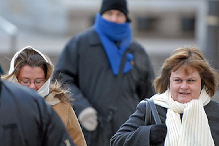 Pedestrians head to work in the early morning extreme low temperatures. This shot is at 15th & Market streets. ( Tom Gralish / Staff Photographer )