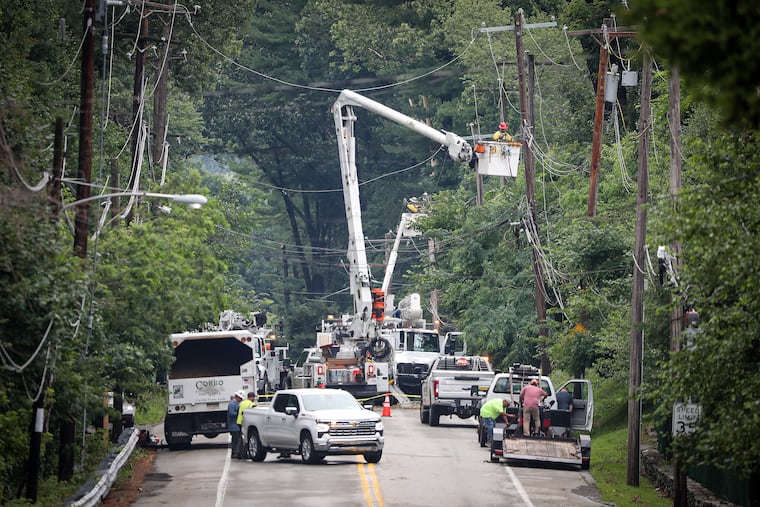 Workers repairing power lines on Palmers Mill Road near Providence Road in Media on Sunday. Storms caused tree and power line damage in area.
