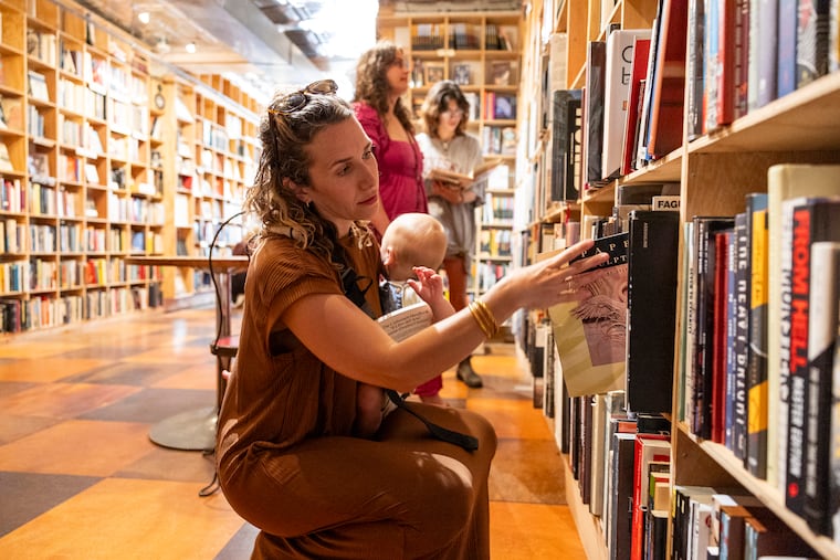 Lindsey Scannapiecco and her son shop inside Queen Village's Brickbat Books, one of her favorite local bookstores.