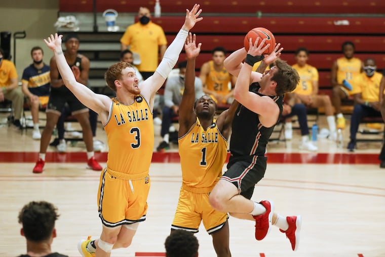 St. Joseph’s Ryan Daly drives for a shot over La Salle’s Christian Ray (3) and David Beatty (1) in the first half at Hagan Arena.