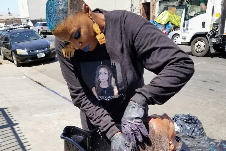 Shirley Raines washing a person's hair in 2018 on Skid Row in Los Angeles.