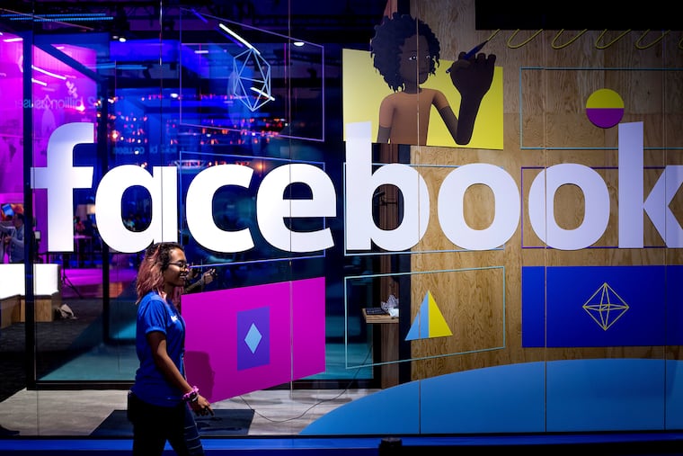A conference worker passing a demo booth at Facebook's 2017 F8 developer conference, in San Jose, Calif.