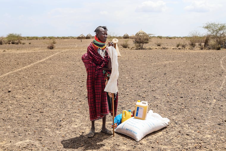 A woman stands beside her food ration after distribution of aid, in Nalemkais Village, Turkana County, Kenya, Feb. 8, 2026.