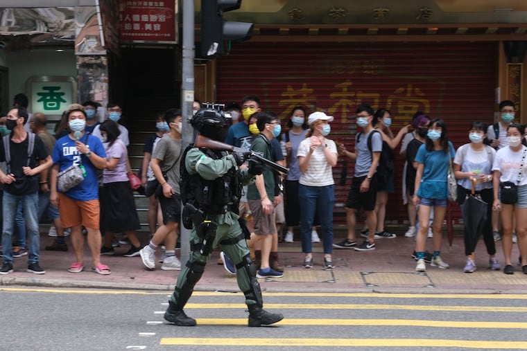 A riot police officer points a tear gas rifle towards demonstrators during a protest in Hong Kong on July 1.