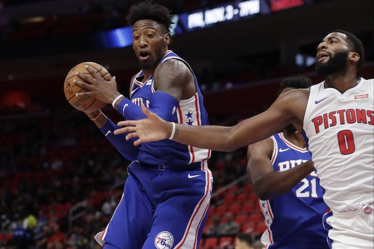 Sixers’ forward Robert Covington (left) grabs a rebound over Detroit Pistons center Andre Drummond.