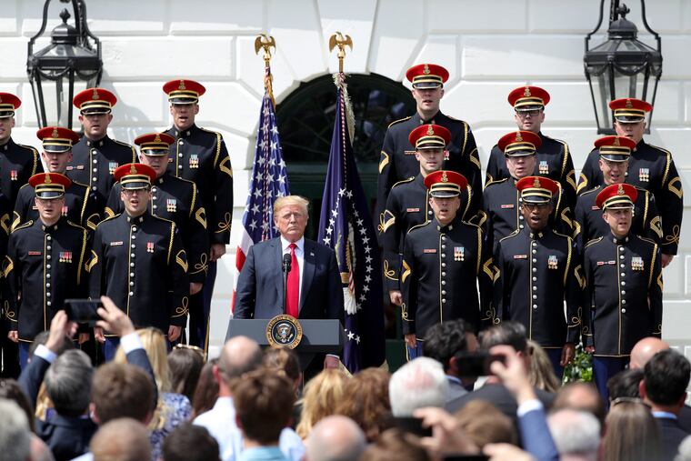 President Trump listens during the singing of "God Bless America" during Tuesday's White House celebration sans the Eagles.