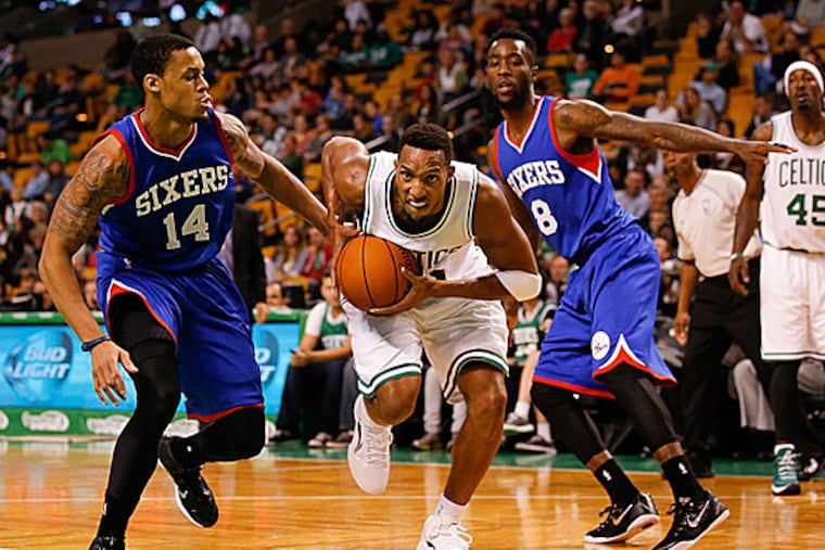 Celtics guard Evan Turner drives the ball through 76ers guards Tony Wroten and K.J. McDaniels. (David Butler II/USA Today Sports)