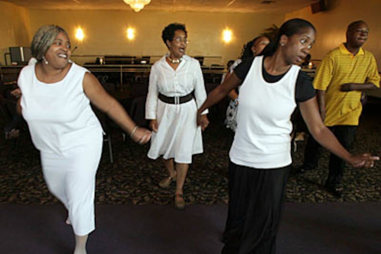 Dancers move their feet while line dancing at Club Destiny at the
Eastwick Worship Center this summer. ( Yong Kim /
Staff Photographer )