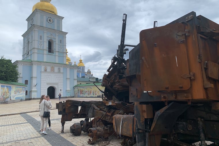 Passersby inspect destroyed military equipment in the plaza of St. Michael's Golden-Domed Monastery in Kyiv, Ukraine.