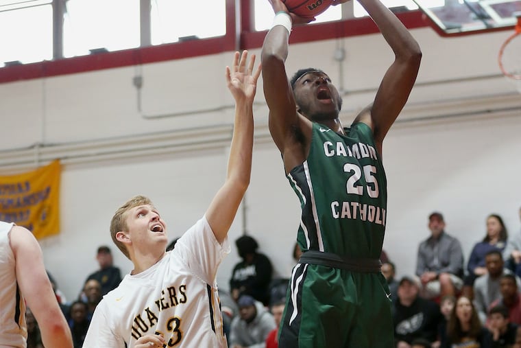 Moorestown's Hayden Greer (33) reaches to defend against Camden Catholic's Babatunde Ajike (25) during a game at Rancocas Valley High School in January of last season.
